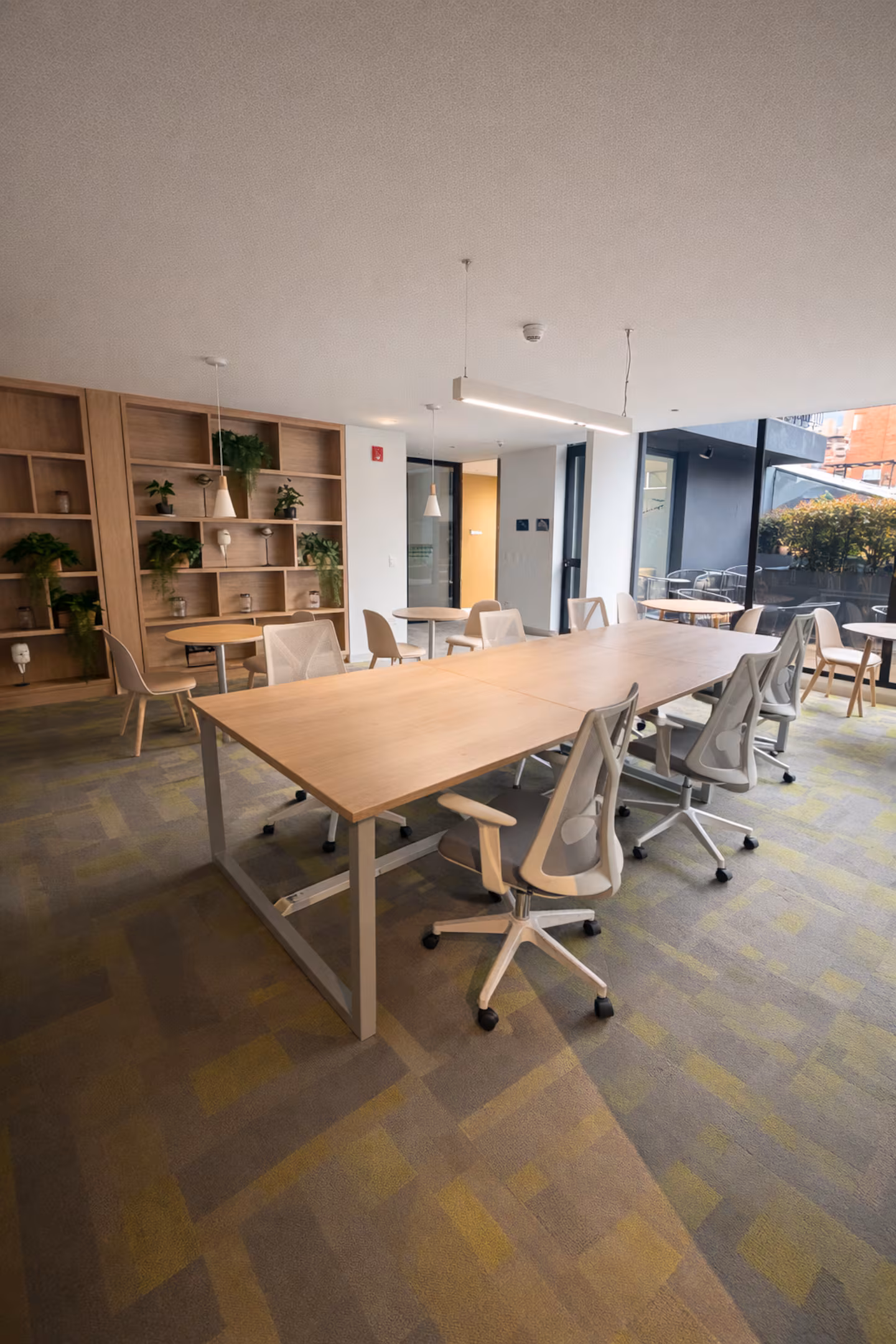 Zona social de trabajo con iluminación natural y mobiliario confort