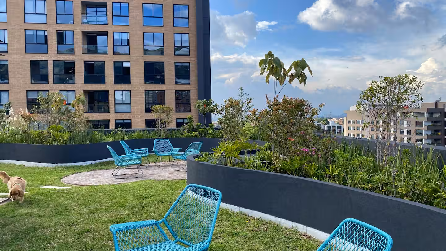 Zona social al aire libre con área BBQ en la terraza del edificio